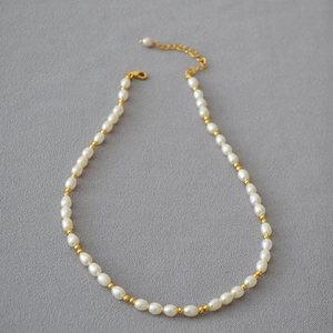 Détail du collier de perles de riz d'eau douce avec perles dorées et fermoir mousqueton