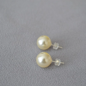 Macro shot of 925 silver large pearl stud earrings with clear silicone backings