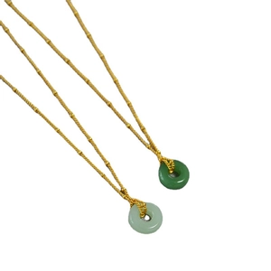Ensemble de colliers en bambou doré avec pendentifs en jade vert sur fond blanc