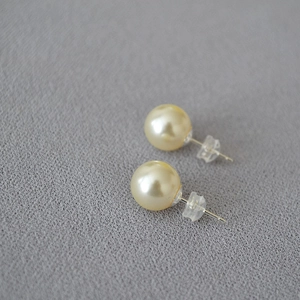 Macro view of large round faux pearl studs with 925 silver pins and silicone backs