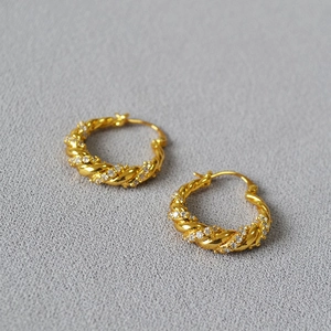 Detail of gold twisted hoop earrings with shimmering micro-pave cubic zirconia inlay