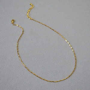 Detailed view of shiny gold-plated minimalist necklace with lobster clasp and heart charm