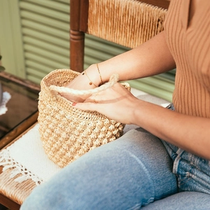 Detail of handmade woven straw handbag with unique crochet bubble texture and sturdy handle