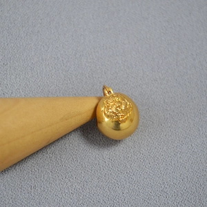Detailed macro view of a 3D brass tiger head charm with antique gold plating and relief details