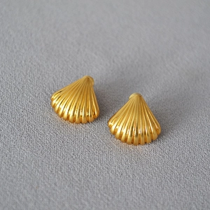 Detail view of vintage brass gold-plated shell earrings with fine radial textures