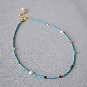 Detail of vintage French necklace with turquoise beads, colorful stones and golden clasp