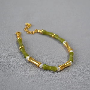 Close-up of green jade bamboo beads and white pearls on a gold adjustable necklace