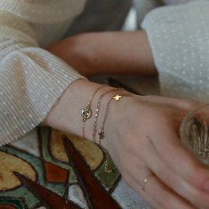 Detailed close-up of a French style gold plated bracelet set with blue eye pendant