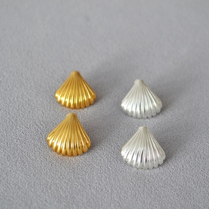 Detail showing scallop-shaped brass and silver plated stud earrings with textured ridges