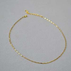 Detail of minimalist 14k gold plated brass collar necklace with shiny twisted link chain
