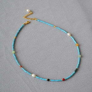 Detail of a French vintage necklace with blue turquoise beads and colorful gemstone accents