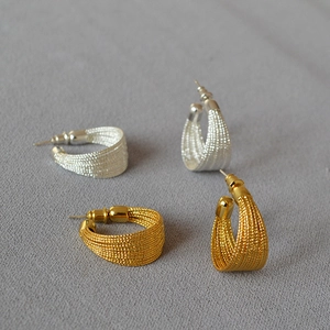 Gold and silver plated C-shaped stud earrings with intricate braided metal texture