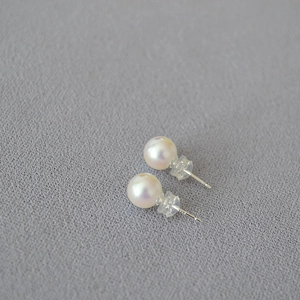 Detailed close-up of minimalist large round pearls with high metallic luster and silver pins