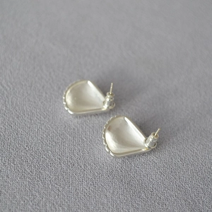Detail view of the silver shell-shaped earring back with secure bullet clutch backings