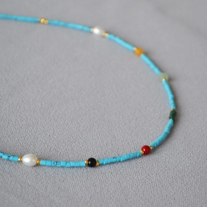 Macro detail of French Vintage turquoise beaded necklace with colorful gemstone accents
