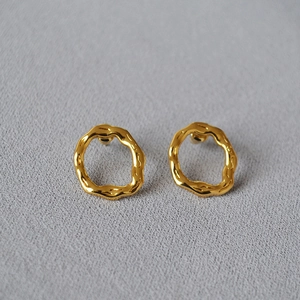 Irregular textured gold plated round stud earrings with a polished lava-like surface