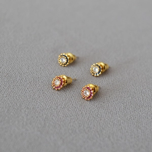 Macro detail of 925 silver flower stud earrings with blue and red cubic zirconia