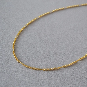 Detail of gold-plated brass necklace featuring interlocking round and long link chains