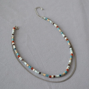 Close-up of double-layer beaded necklace with colorful macaron beads and silver chain detail