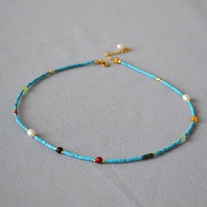 Detail of vintage beaded necklace featuring blue turquoise and colorful pearl accents