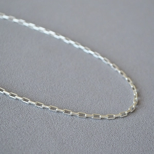 Vue détaillée d'un collier à maillons rectangulaires géométriques argentés minimalistes
