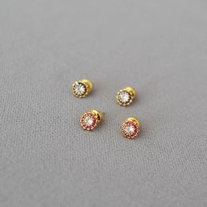 Close-up of floral earrings with sparkling blue and pink cubic zirconia crystals