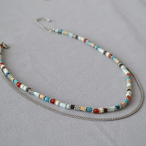 Detail of bohemian double-layer necklace with colorful beads and adjustable metal chain