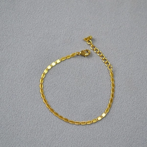 Detail of adjustable gold-plated brass chain with lobster clasp and drop pendant
