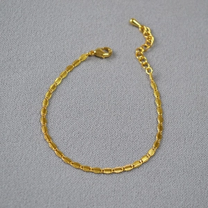 Detail of gold plated brass chain necklace featuring textured links and adjustable drop pendant