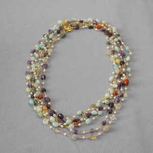 Detail of bohemian multilayer necklace with colorful natural stones and white pearls