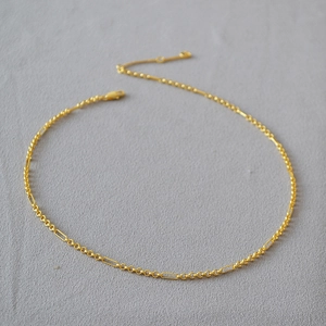 Detail of gold-plated brass chain with minimalist interlocking ring and link structure