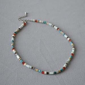 Detail of colorful bohemian beads necklace with turquoise accents and silver lobster clasp