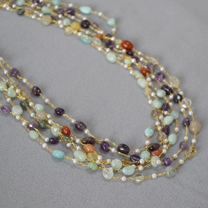 Detail of multi-layered necklace with colorful natural stone beads and freshwater pearls