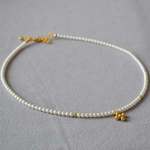 Minimalist pearl necklace with a golden cross pendant and OT toggle clasp closure