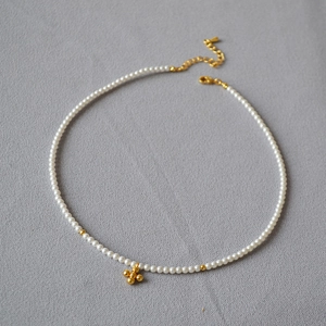 Detail of pearl necklace with gold star cross pendant and adjustable lobster clasp