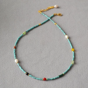 Macro detail of French vintage style turquoise beaded necklace with golden clasp