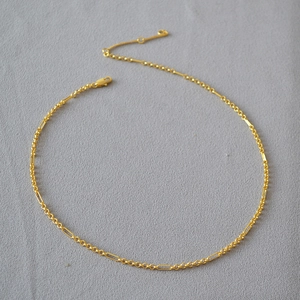 Macro shot of minimalist gold-plated brass chain with interlocking round and rectangular links
