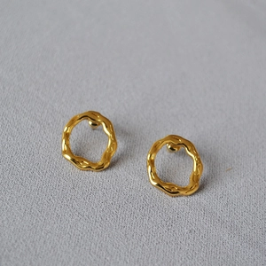 Irregular gold wave earrings with minimalist metal texture on grey background