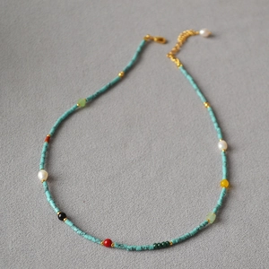 Close-up of vintage multi-color beaded necklace with blue turquoise and gold clasp