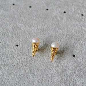 Detail of ice cream cone earrings with fresh pearls and golden textured metal finish