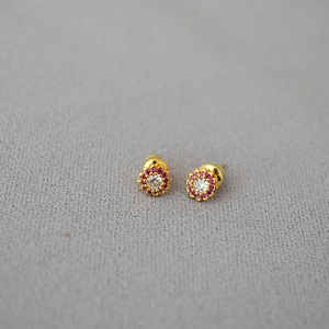 Detailed macro view of gold flower earrings with pink and white crystal zircon stones