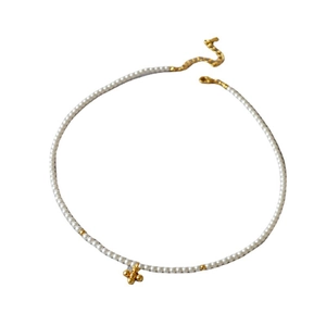 Elegant pearl choker necklace with a gold cross pendant and small metallic bead accents