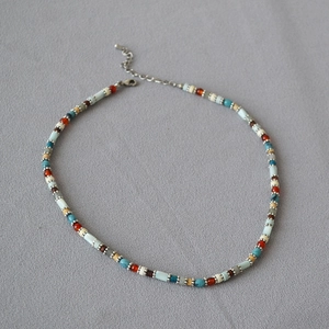 Detail of colorful macaron beaded necklace with silver lobster clasp and extension chain