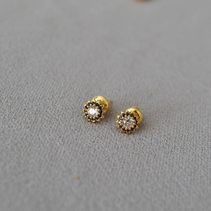 Macro detail of sunflower studs featuring blue sapphire-tone gems and center zirconia