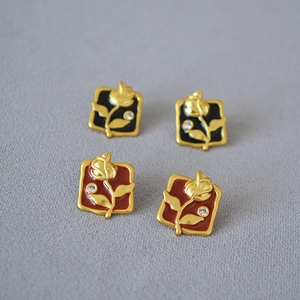 Macro detail of square floral enamel earrings with relief gold rose and zircon stones