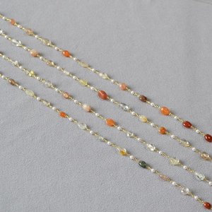 Close-up of handmade necklace with colorful semi-precious stones and white pearls