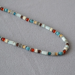 Detail of bohemian style double-layer necklace with colorful macaron beads and wood accents