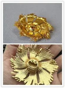 Detail view of gold floral brooch back with brushed metal texture and pin closure