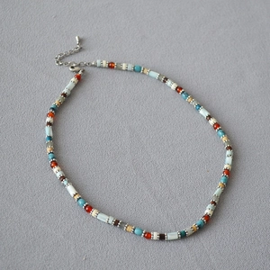Detail view of colorful beaded necklace with turquoise beads and lobster clasp closure