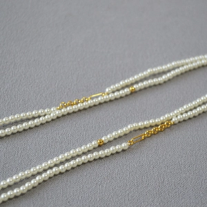 Close-up of elegant small pearl chain with gold metal geometric accents for women